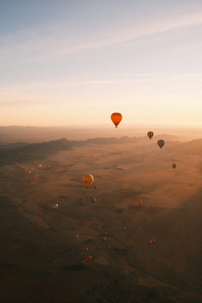 Hot air balloon Dubai flight floating above desert dunes at sunrise